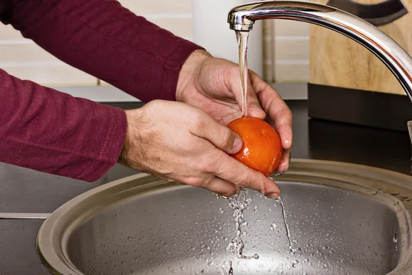 Крупним планом руки людини миють помідор — стокове фото