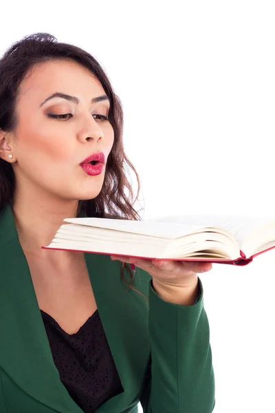 Beautiful young woman holding an open book blowing on it — Stock Photo, Image