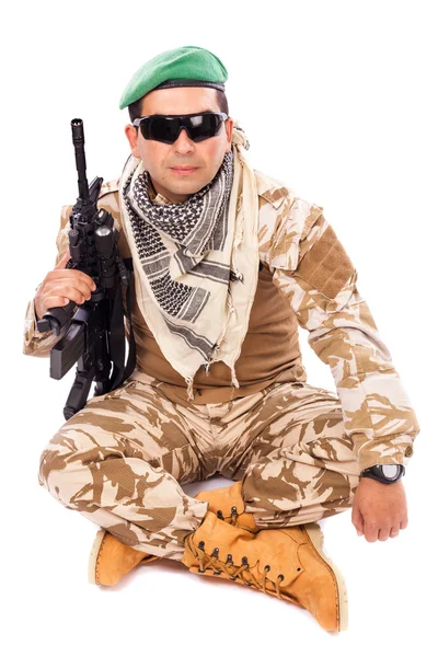 Young soldier with beret and glasses holding an automatic — Stockfoto