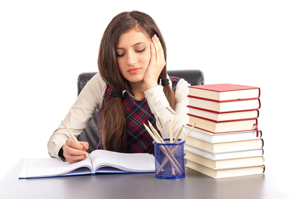 Porträt eines gelangweilten Schulmädchens, das am Schreibtisch seine Hausaufgaben macht — Stockfoto