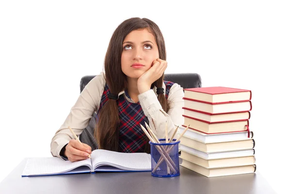 Porträt eines gelangweilten Schulmädchens, das am Schreibtisch seine Hausaufgaben macht — Stockfoto