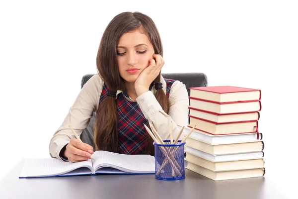 Porträt eines gelangweilten Schulmädchens, das am Schreibtisch seine Hausaufgaben macht — Stockfoto