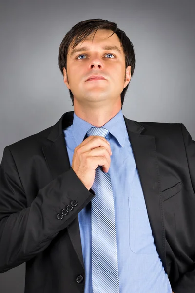 Portrait of a young businessman adjusting his neck tie getting r — Stock Photo, Image