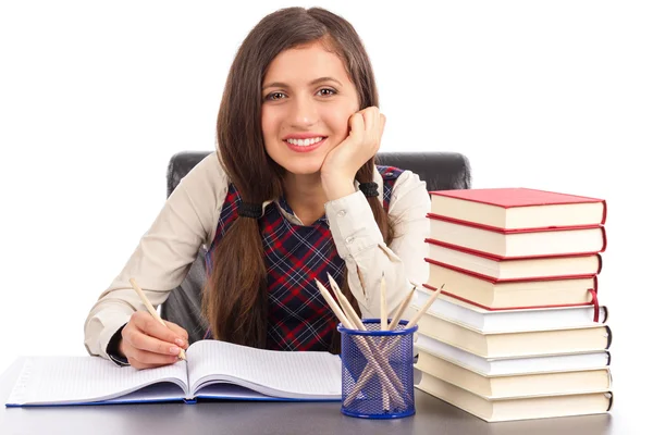 Estudio de una colegiala sonriente haciendo su tarea — Foto de Stock