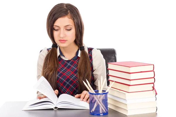 Retrato de una colegiala leyendo en el escritorio — Foto de Stock