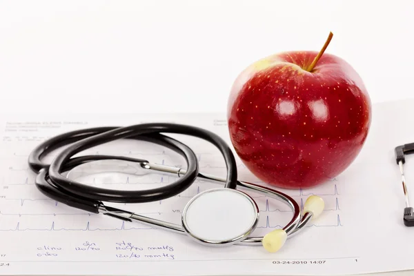 Pomme rouge et stéthoscope sur un électrocardiogramme (ECG) — Photo