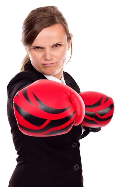 Portrait of angry businesswoman with boxing gloves punching — Stock Photo, Image