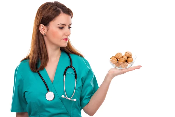 Doctora joven con estetoscopio sosteniendo nueces — Foto de Stock