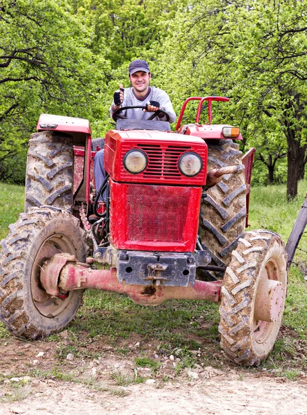 Mladý zemědělec řídit traktor — Stock fotografie