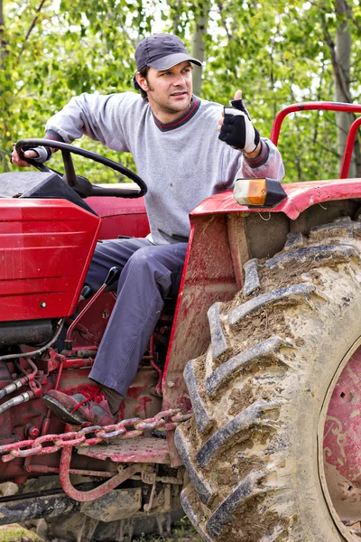 Fiatal mezőgazdasági termelő vezetői a traktor, és így az ok jele — Stock Fotó