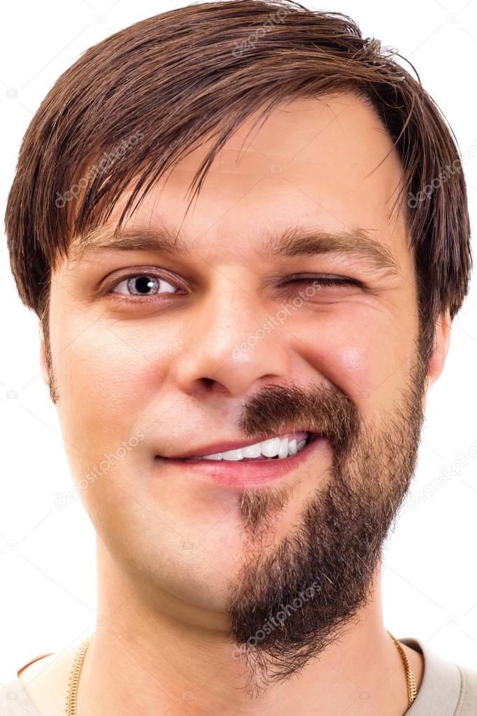 Closeup of an expressive young man with  beard on half of the fa