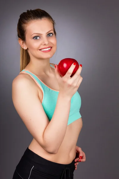 Retrato de mujer hermosa feliz en ropa de fitness sosteniendo un rojo — Foto de Stock