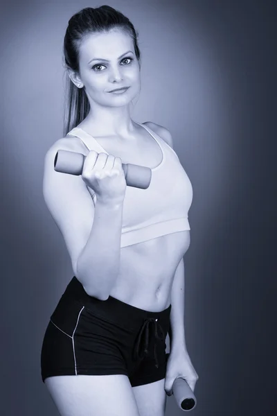 Young fitness woman lifting dumbbells — Stock Photo, Image