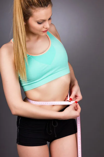 Portrait of beautiful young woman standing  with measuring tape — Stock Photo, Image