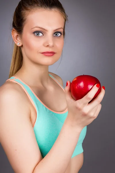 Retrato de cerca de una hermosa joven sosteniendo una manzana roja — Foto de Stock