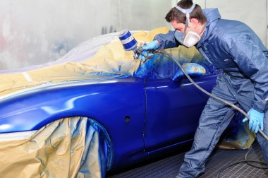 Worker painting a car. clipart