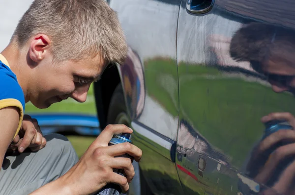 Chlapec postřik auto. — Stock fotografie