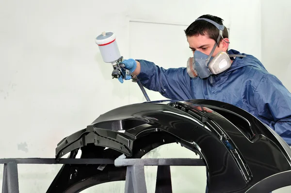 Trabalhador pintando um carro . — Fotografia de Stock