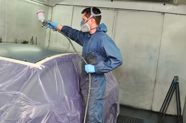 Trabalhador pintando um carro . — Fotografia de Stock