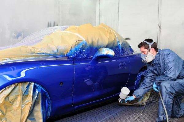 Arbeiter beim Lackieren eines Autos. Stockfoto