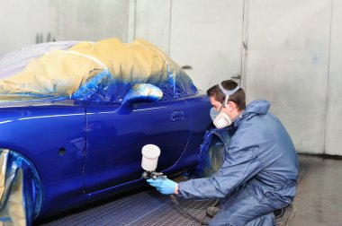 Worker painting a car. clipart