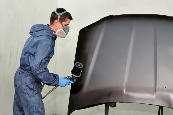 Trabalhador pintando um carro . — Fotografia de Stock