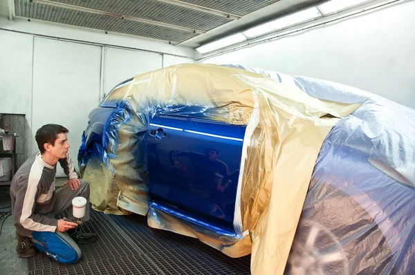 Trabajador pintando un coche — Foto de Stock