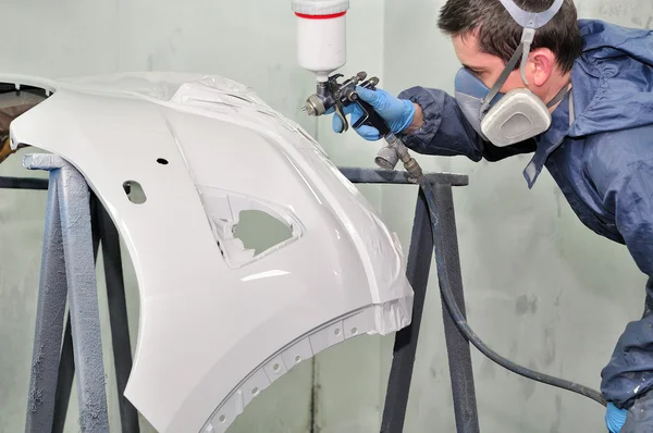 Trabajador pintando un parachoques de coche . —  Fotos de Stock