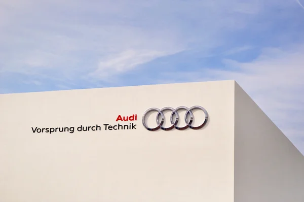 Audi, bord à travers la technologie sur un mur blanc contre le ciel bleu . — Photo