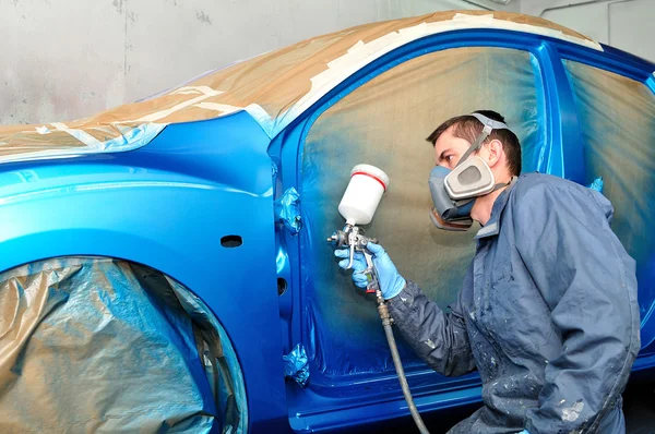 Arbeiter lackiert blaues Auto. — Stockfoto