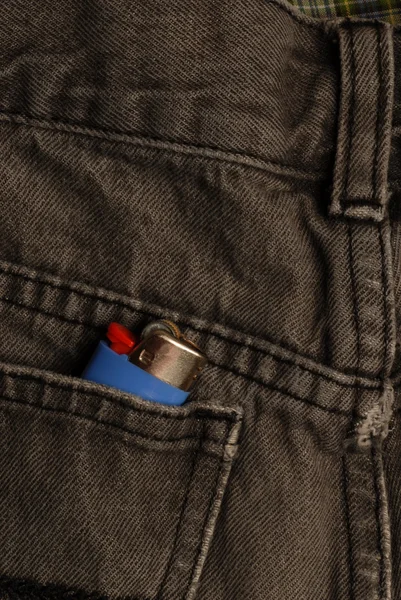 Black blue jeans with lighter in the back pocket — Stock Photo, Image