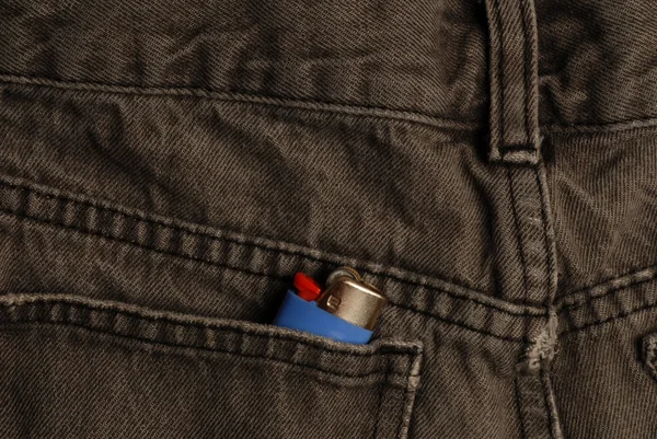 Black denim jeans with a lighter in the back pocket — Stock Photo, Image