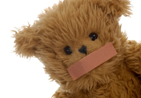 Stuffed teddy bear with bandaid on mouth — Stock Photo, Image