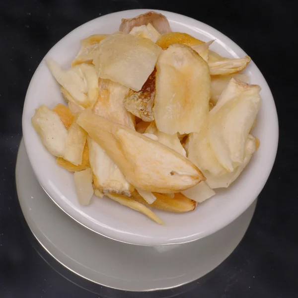 Dried minced garlic in white dispenser on black background — Stock Photo, Image