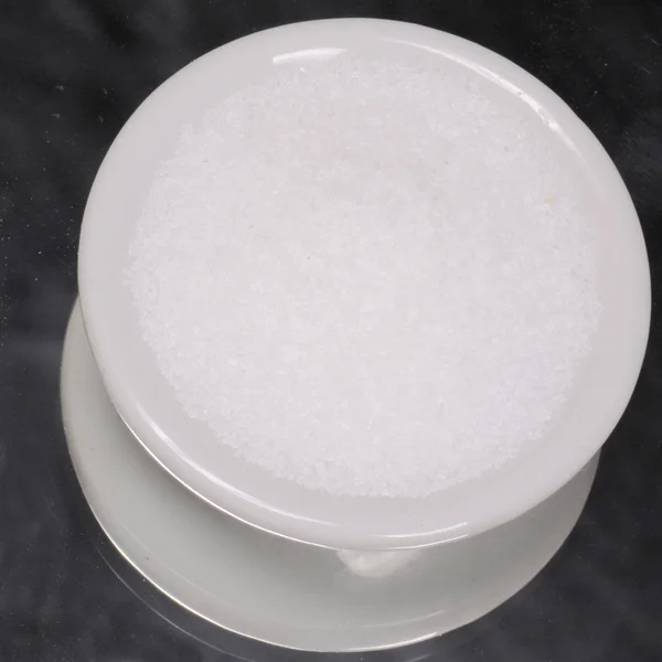fine ground table salt in white dispenser on black background