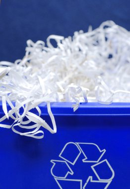 blue recycle bin with shredded paper spilling out clipart