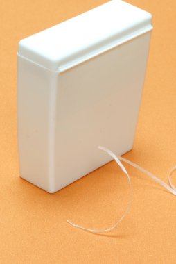 waxed dental floss in an unmarked container clipart