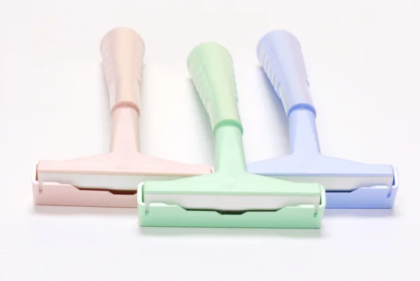 three disposable razors with safety caps on white background