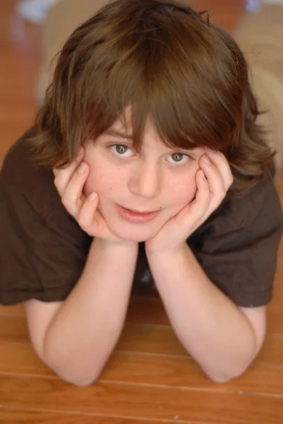 Goed uitziende jongen met verlegen expressie met kin rusten in handen — Stockfoto