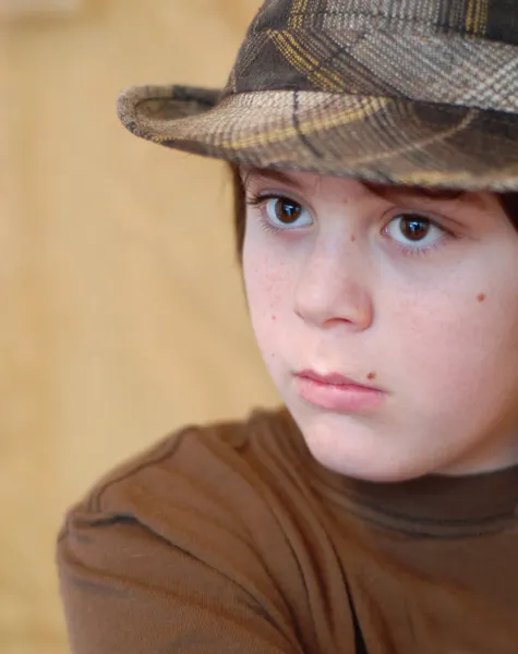 Menino de doze anos de idade usando chapéu xadrez quadril — Fotografia de Stock