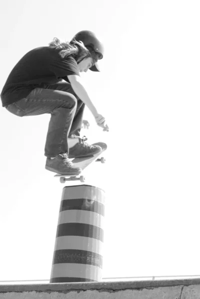 Skateboarder en acción saltando pilón en flyout —  Fotos de Stock