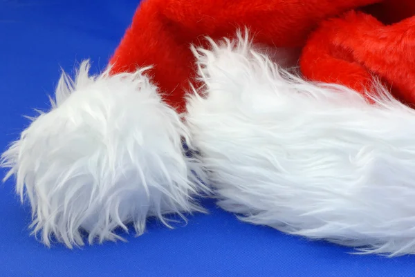 Detalhes sobre chapéu de santa claus no fundo azul — Fotografia de Stock