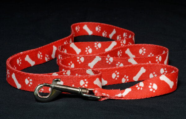 red dog leash with paw prints on black background