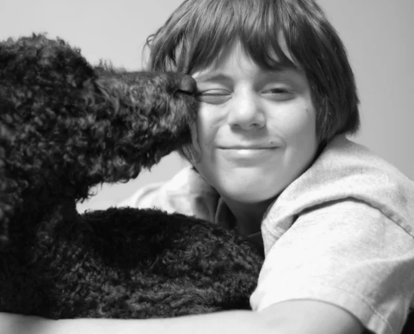 12-letni chłopiec i jego pies lizać jego twarz — Zdjęcie stockowe
