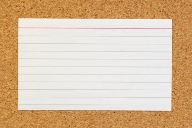 lined index card on cork board background