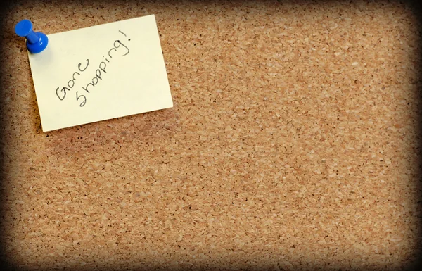 Cork board with note posted saying gone shopping — Stock Photo, Image