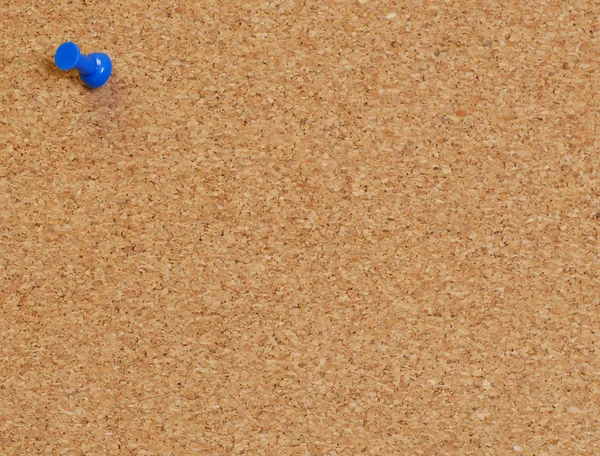 Cork board with blue push pin or thumb tack — Stock Photo, Image