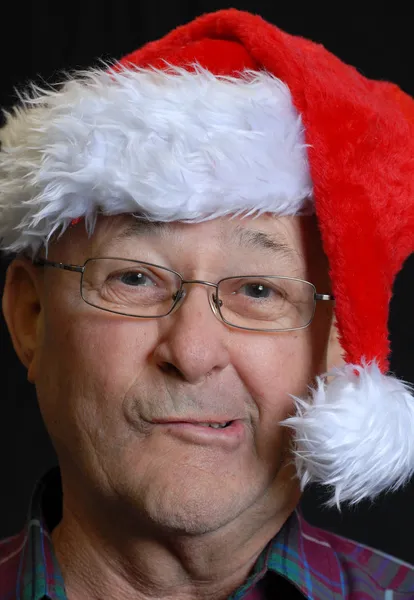 Senior man in santa hat making funny face — Stock Photo, Image