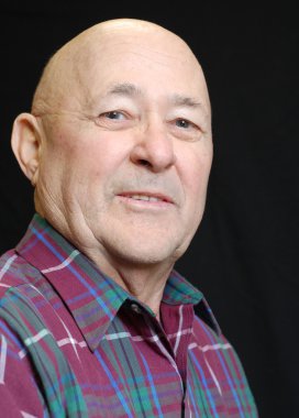 siyah arka plan üzerine kıdemli kel adam portresi