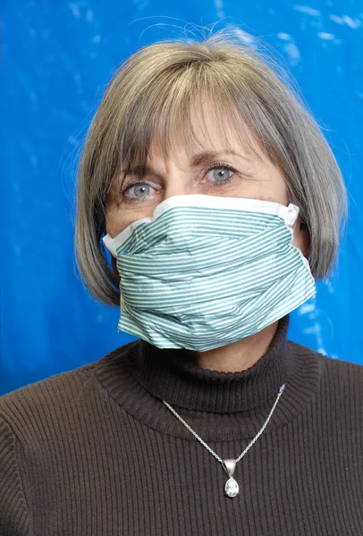 Attractive senior woman wearing protective medical mask — Stock Photo, Image